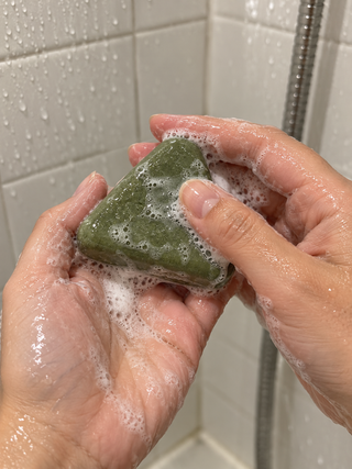 Testeuse qui fait mousser le savon Charmelle entre ses mains sous la douche